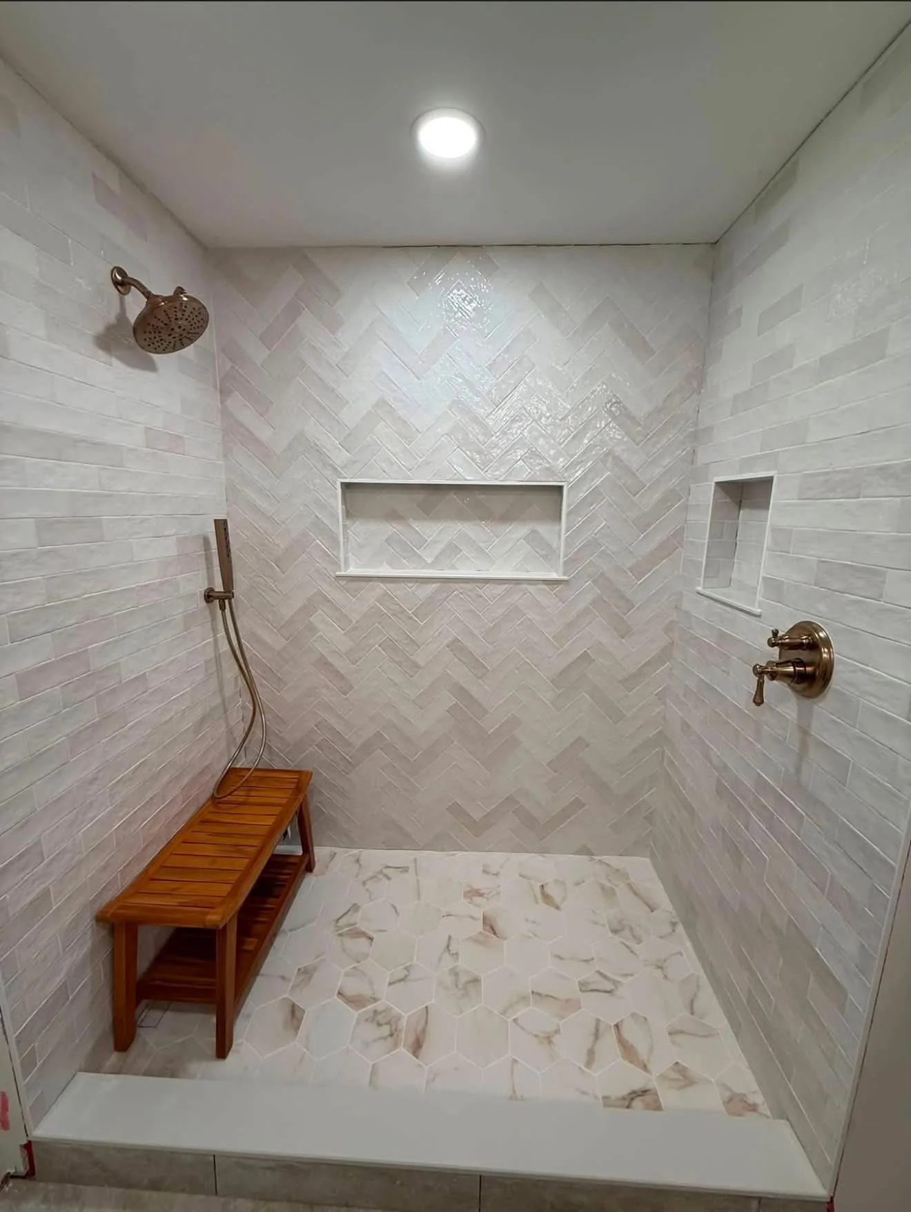 Finished shower with herringbone feature wall, recessed niches and hexagonal floor