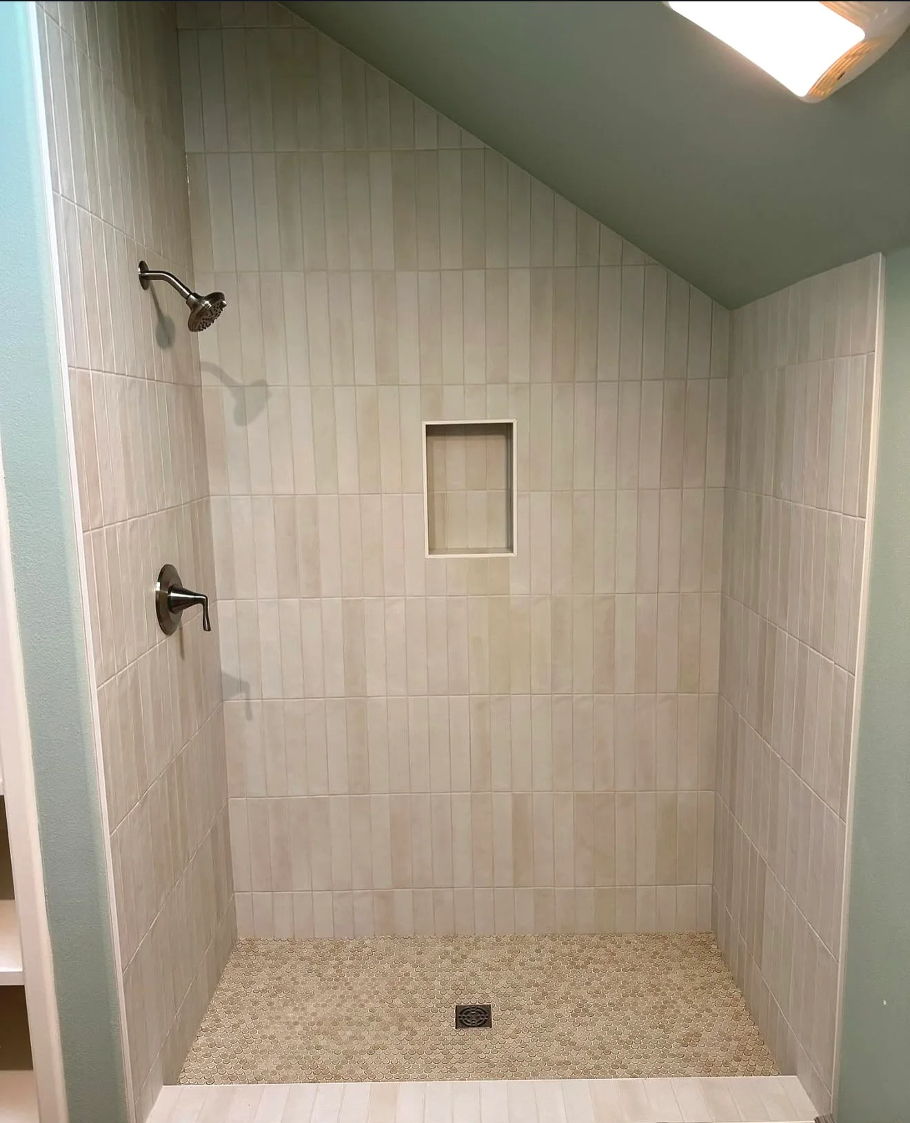 Finished tiled shower with a recessed niche, mosaic floor and square drain