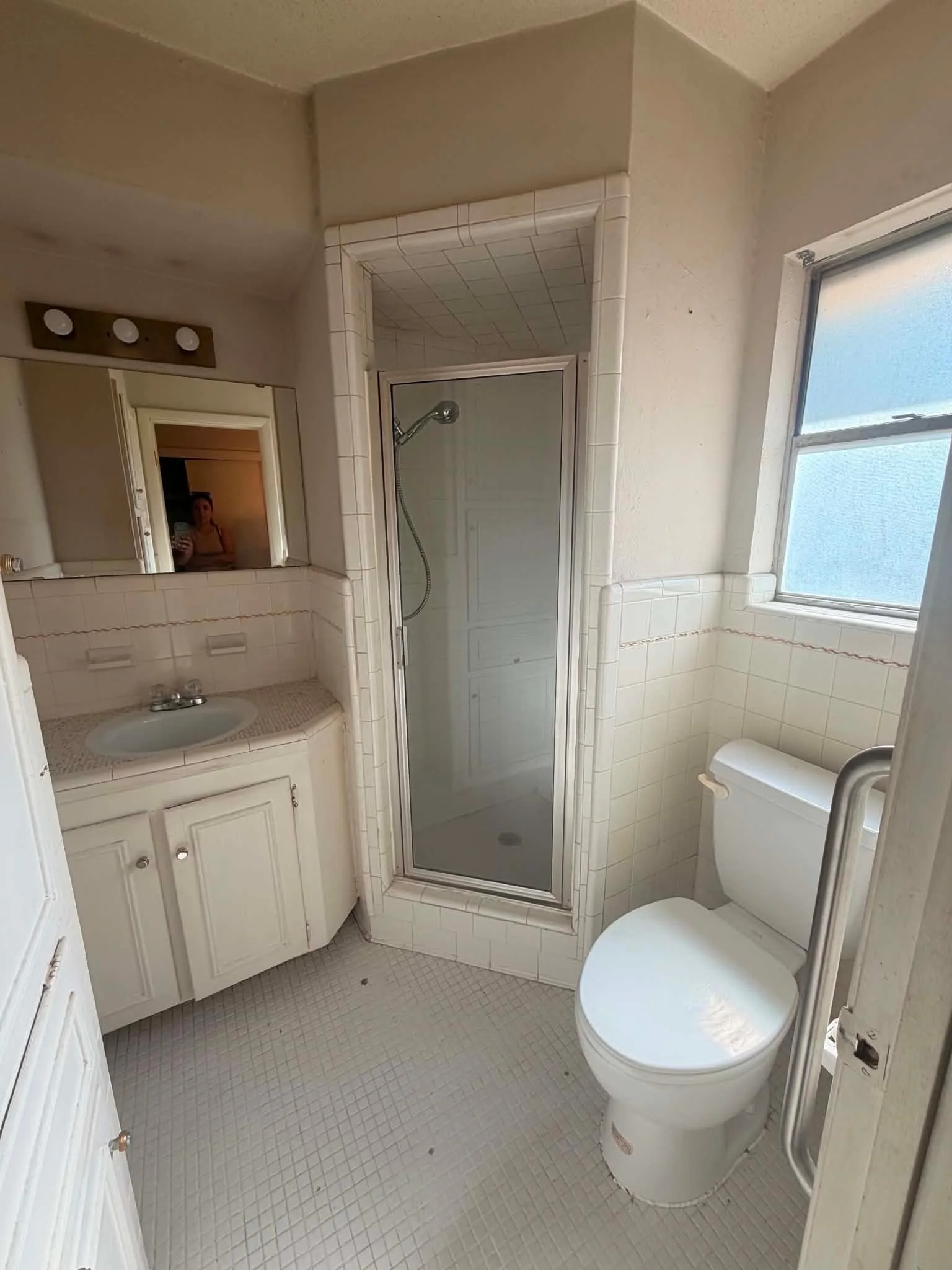 Bathroom with white vanity, toilet and glass-enclosed shower