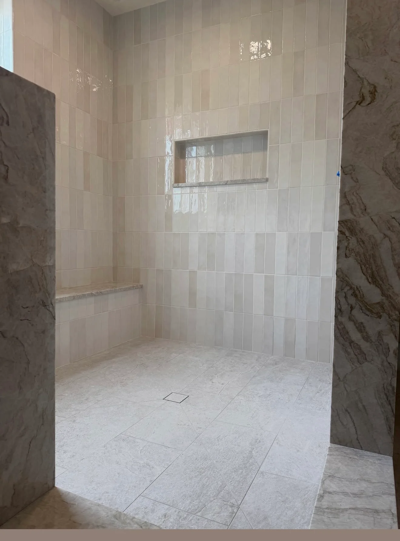 Tiled walk-in shower with a built-in bench and recessed niche