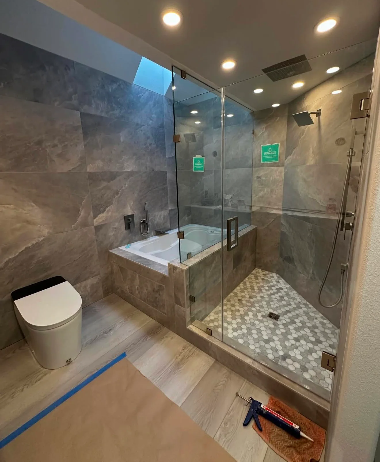 Tiled bathroom during final finishing, with protective floor covering and tools