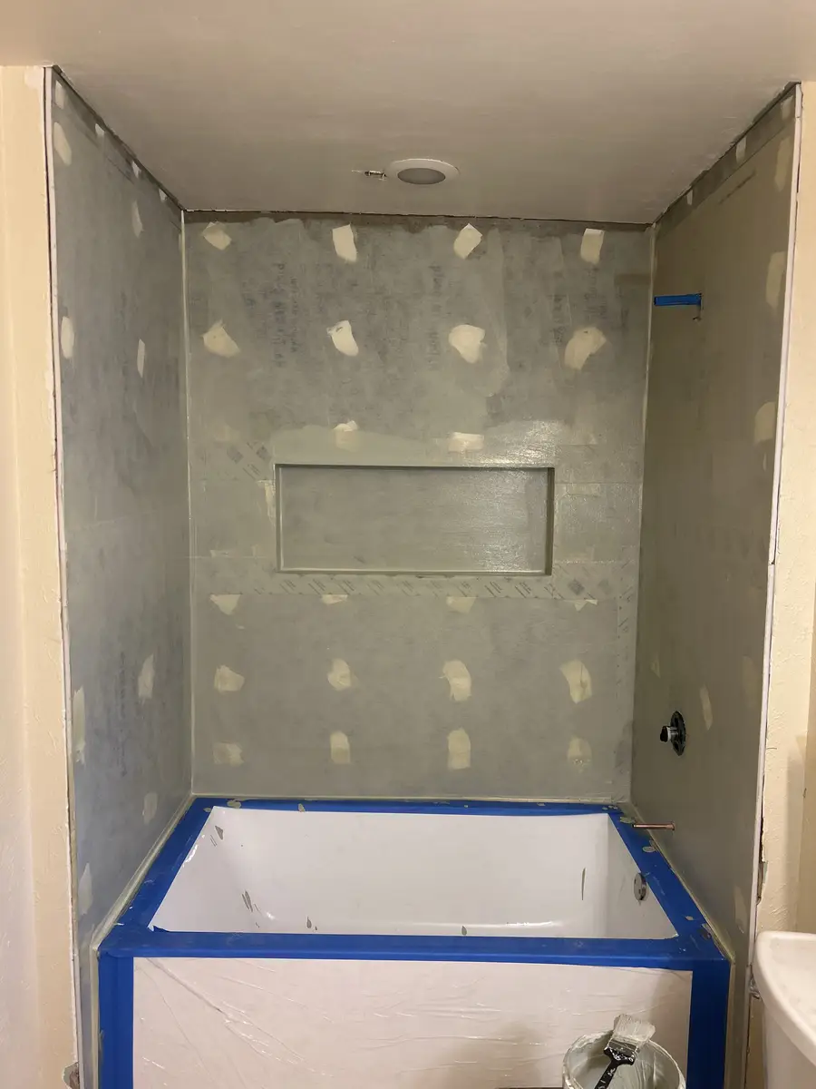 Shower walls with cement board installed and shampoo niche framed before waterproofing