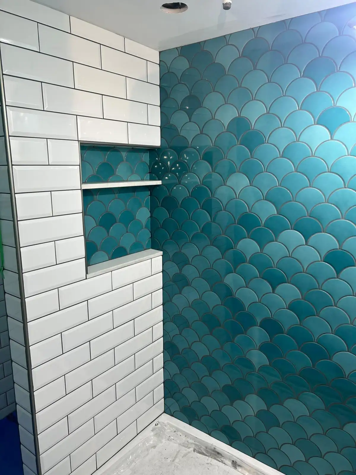Gorgeous teal fish scale tile with white subway tile and niche in Fort Worth bathroom