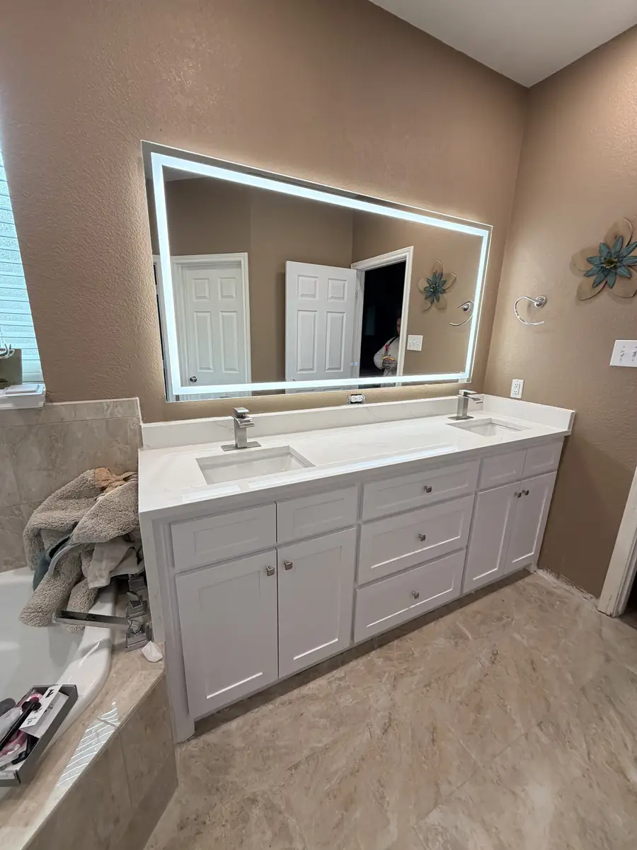 New white double vanity with quartz countertop and LED backlit mirror installed by Water and Stone in Arlington TX